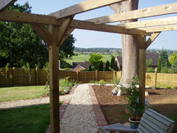 A photo after with new planting scheme, fence, pergola, deck and paths